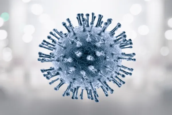 Nahaufnahme eines kugelförmigen Virus mit stachelartigen Auswüchsen vor unscharfem Hintergrund.