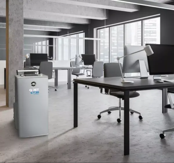 Modernes Büro mit mehreren Schreibtischen, Computern und einem grauen Q-JET CT20 Luftreiniger auf dem Boden.