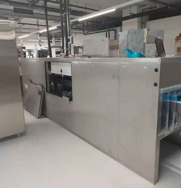 Große, silberne Industrieanlage mit mehreren Fächern und offenem Fach an der linken Seite in einer hellen Halle.